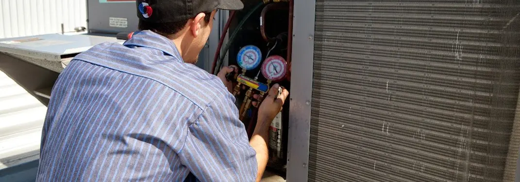 HVAC technician servicing a condenser unit in Mount Washington